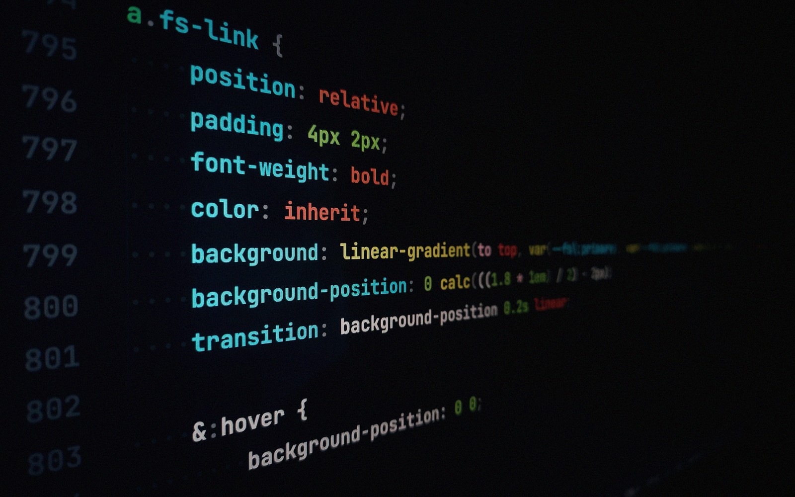 CSS code on a dark screen showing styling rules for a link class with hover effect